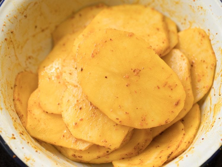 spice powders and salt mixed well with the potato slices. 