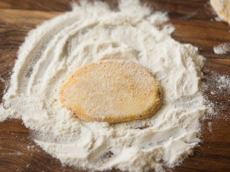 dredging a potato slice in rice flour. 