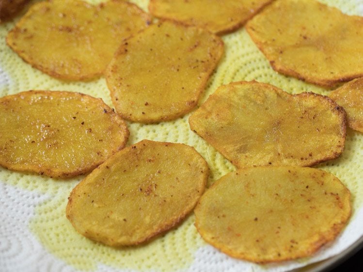 fried potato slices kept on kitchen paper towels. 