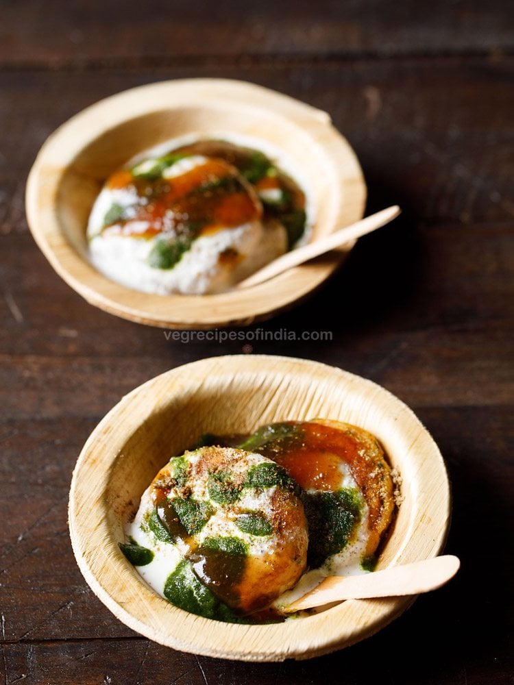 aloo tikki chaat served in individual wooden bowls with spoons and text layover. 