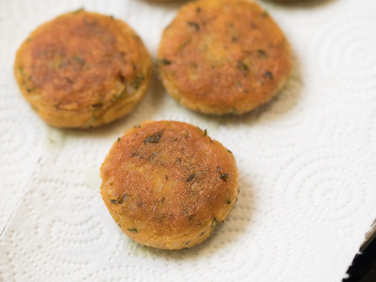 fried aloo tikkis on kitchen paper towels. 