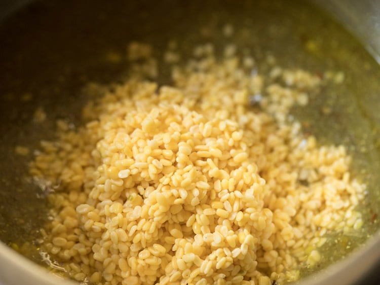 drained moong dal added to pot for making bajra khichdi recipe.