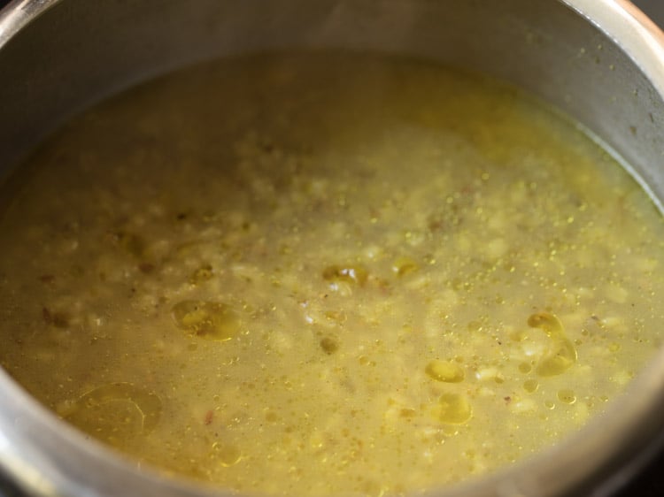 the lid of the bajra khichdi pressure cooker is removed.