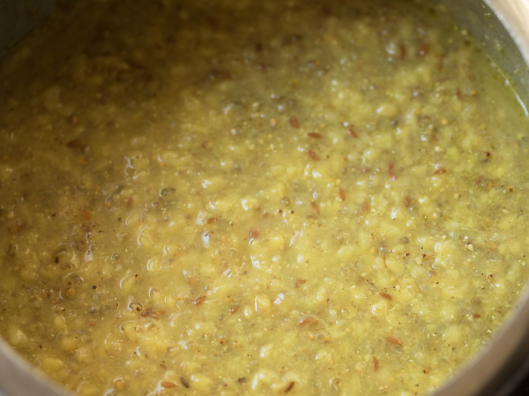 both the bajra and moong dal are fully cooked and the mixture looks pale yellow and a little soupy.