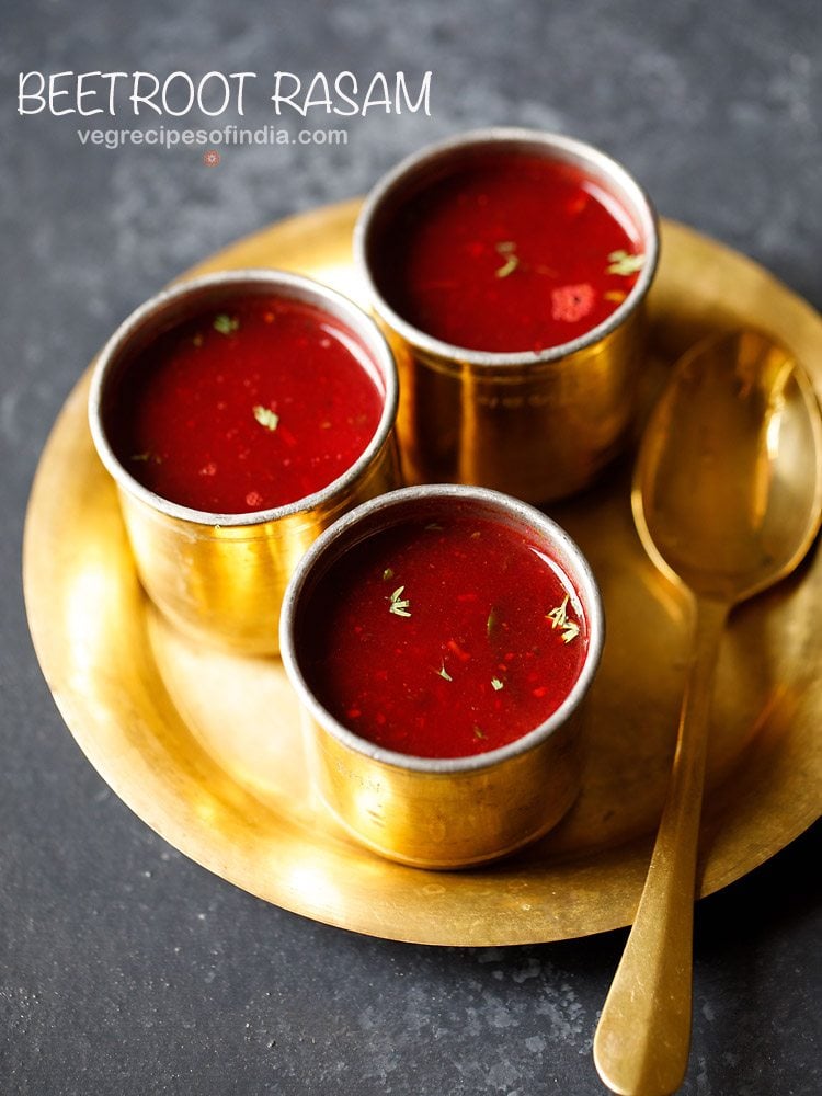 beetroot rasam served in 3 brass bowls with a spoon kept on the side on a brass plate and text layovers.