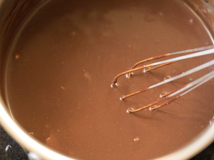 prepared chocolate icing in the pan to make chocolate biscuit cake