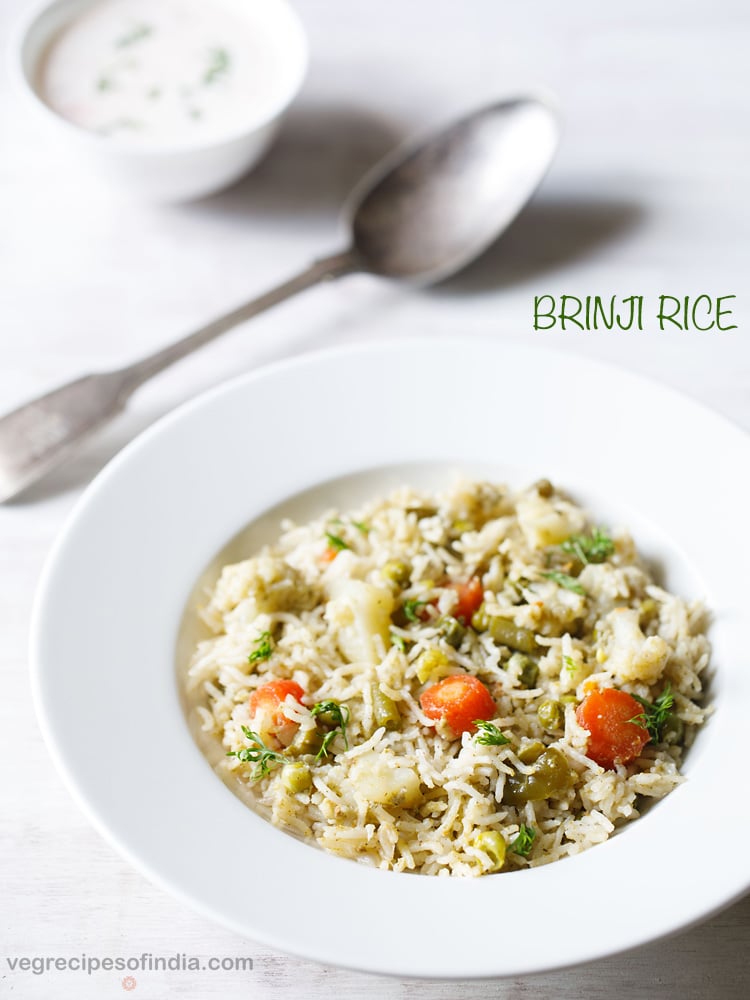 brinji rice served in a white bowl with a spoon, a small bowl of raita kept on the top left side and text layovers.