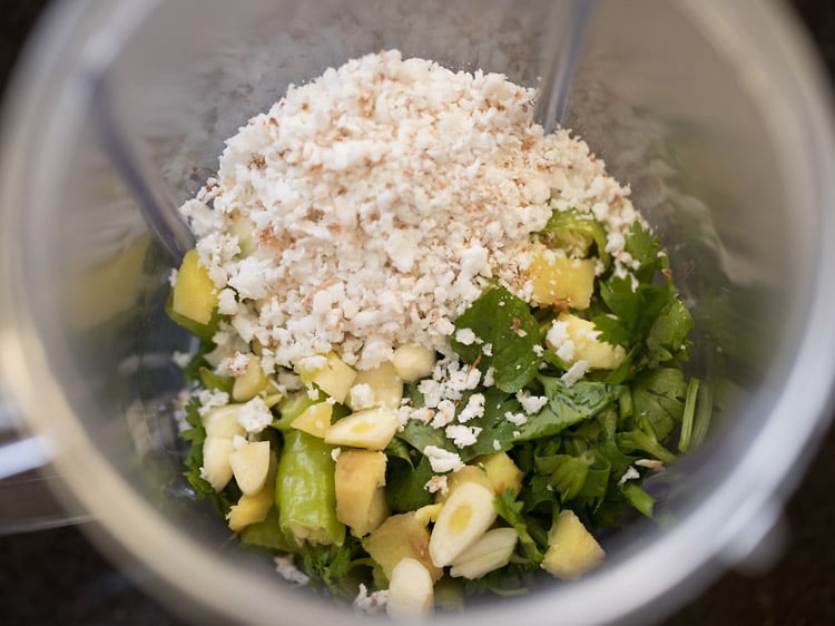 chopped coriander leaves, chopped mint leaves, chopped green chilies, chopped ginger, chopped garlic and grated fresh coconut added to a grinder jar. 