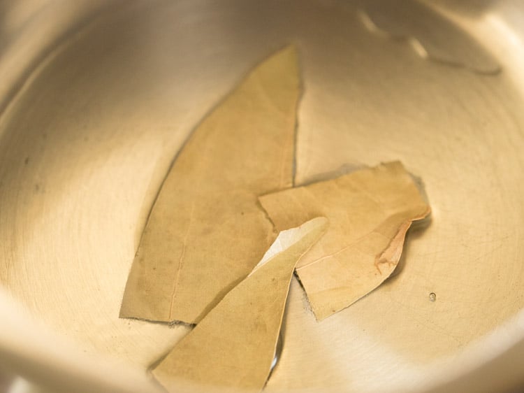 bay leaves added to hot oil in pressure cooker. 