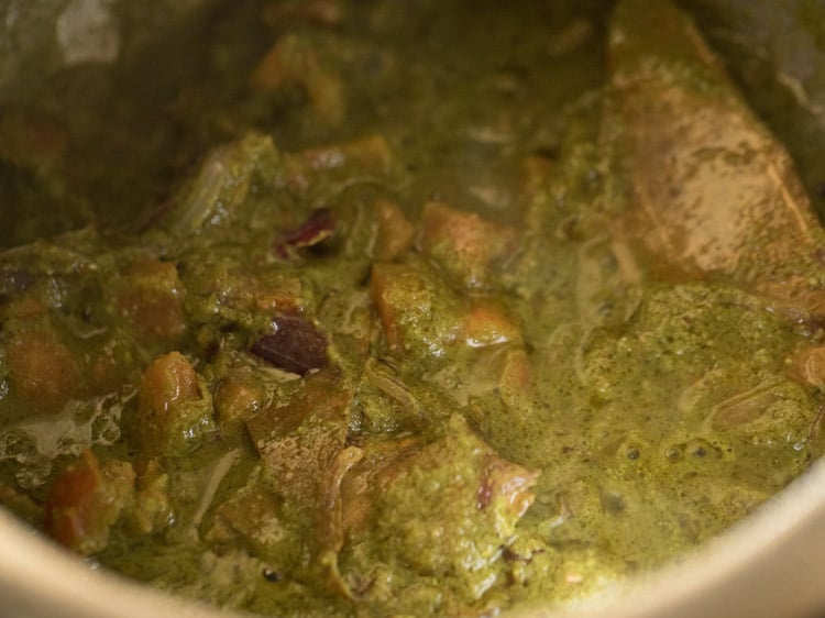 sautéing masala paste with the onion-tomato mixture till oil releases from the sides of the pan. 