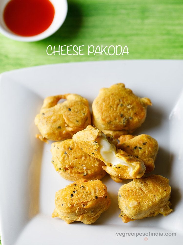 cheese pakora served on a white plate with a small bowl of tomato sauce kept in the background and text layover.