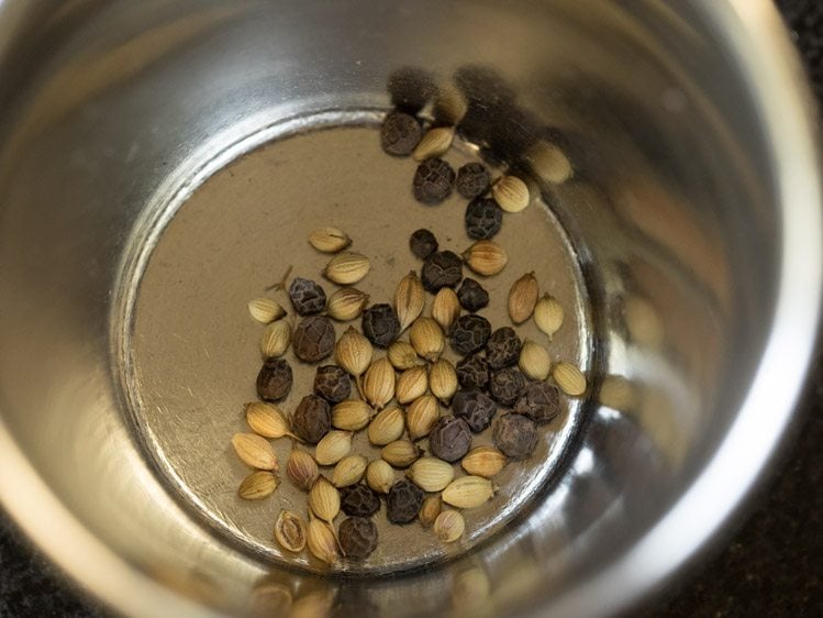 black peppercorns and coriander seeds added in a mortar. 