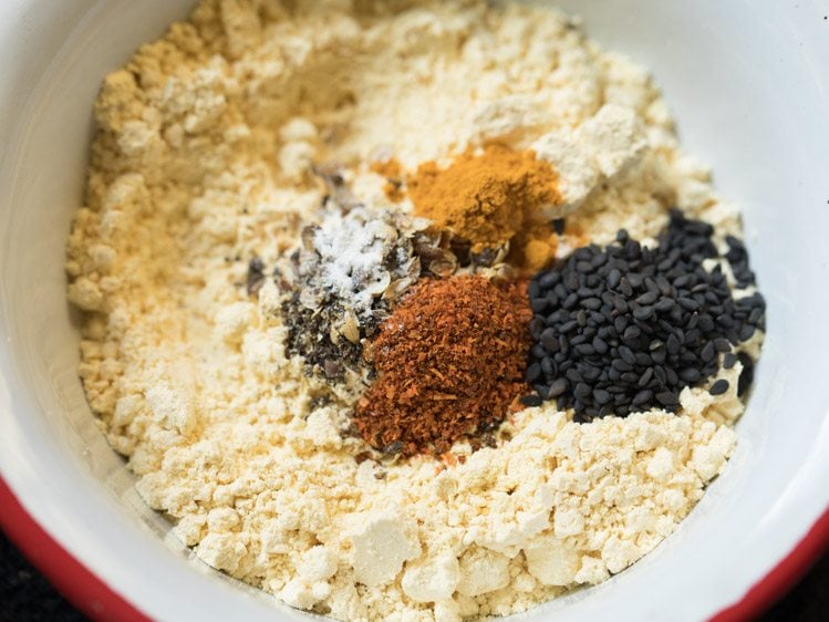 asafoetida, baking soda, turmeric powder, red chili powder and black sesame seeds added to besan. 