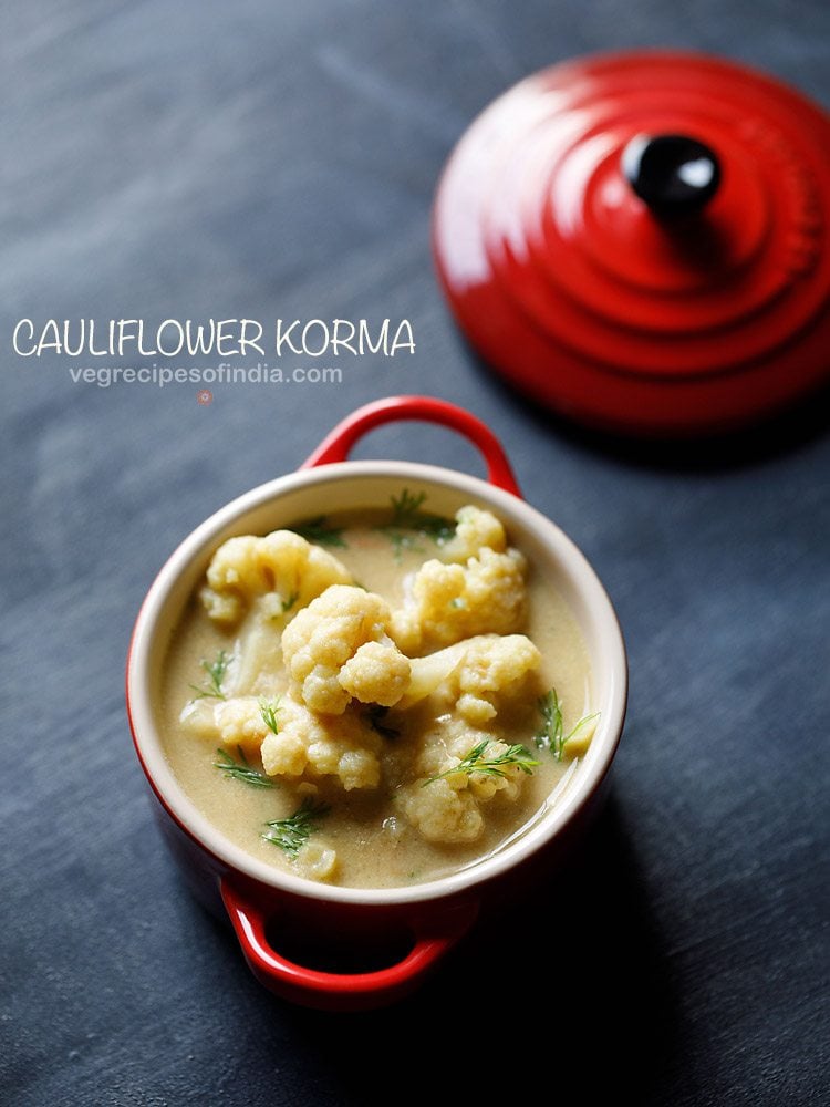 top shot of cauliflower with fresh herbs in kurma gravy, served in small red bowl with a text layover