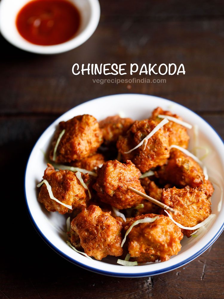 chinese pakoda garnished with cabbage shreds and served on a white plate with a bowl of schezwan sauce kept on the top left side and text layover.