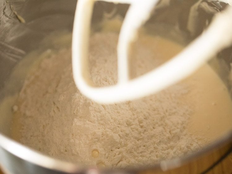 mound of flour on mixed liquid ingredients.