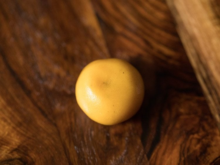 one dough ball kept on lightly greased wooden board. 