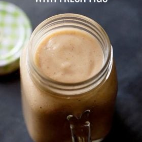 fig smoothie in a drinking glass jar with the lid on the side.