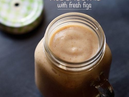 fig smoothie in a drinking glass jar with the lid on the side.