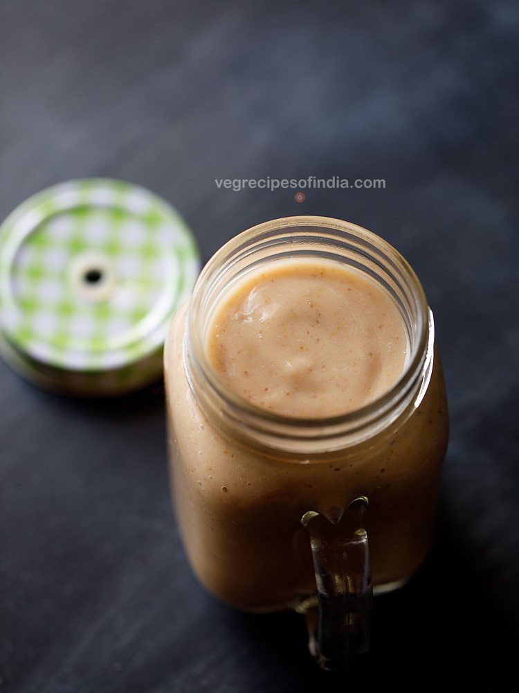 figs smoothie in a drinking glass jar  with the lid on the side 