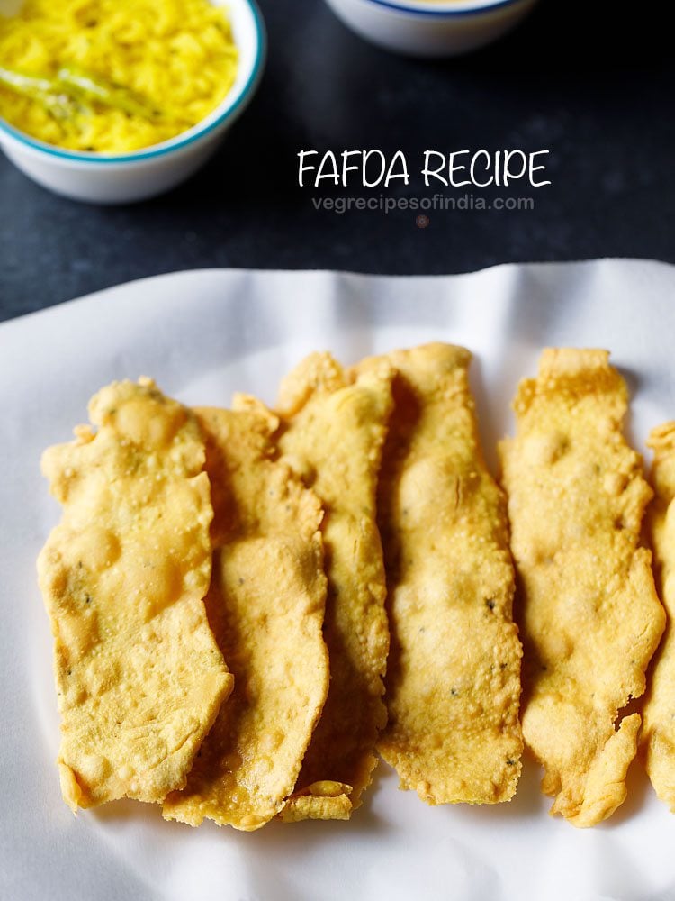 fafda served on a butter paper lined plate with a bowl of papaya sambharo kept on the top in the background with text layover. 