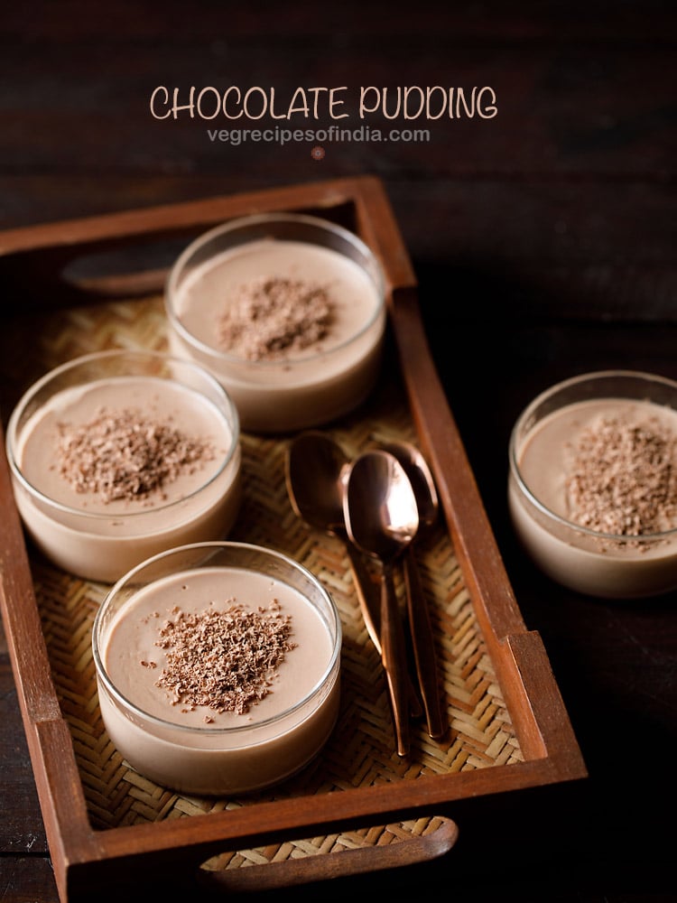 chocolate in bowls topped with grated semi-sweet chocolate with three copper spoons by the side on a mat tray