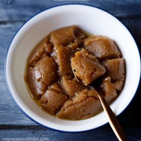 kada prasad served in a white bowl with a spoon in it and text layovers.