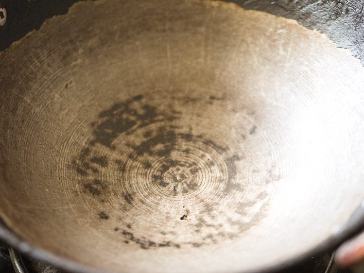 heating heavy bottomed pan for frying whole wheat flour for karah prasad. 