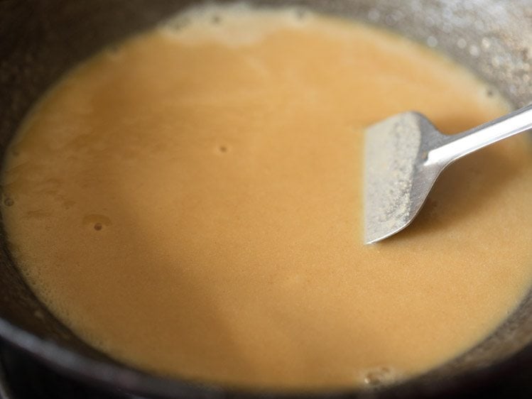 stirring and frying whole wheat flour in ghee for making karah prasad. 