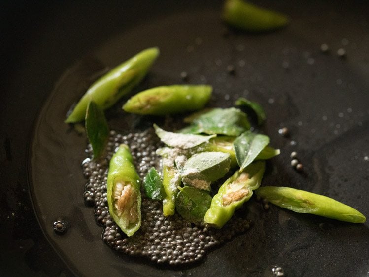 green chili pieces, curry leaves and asafoetida added to the pan. 