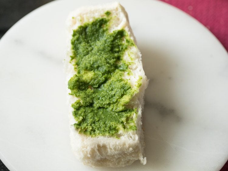 green chutney spread on both sides of the pav. 