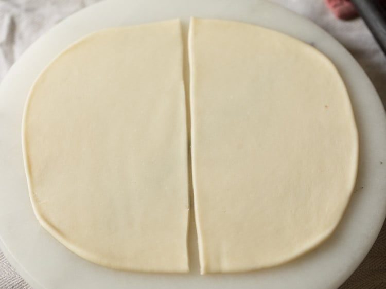 dough disc cut into halves from the center. 