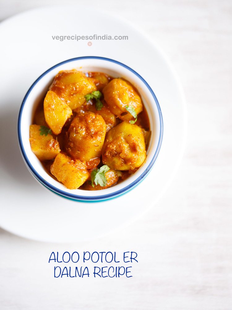 aloo potoler dalna garnished with coriander leaves and served in a blue rimmed white bowl with text layovers.
