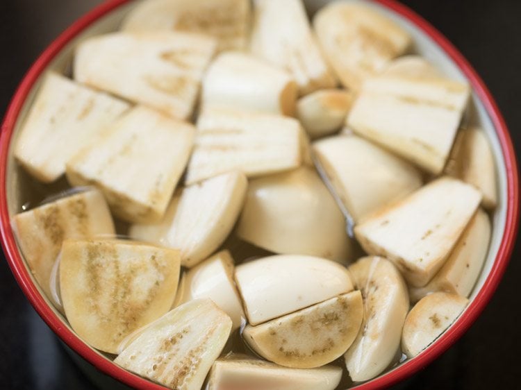 Closeup shot of diced eggplant in bowl of water.