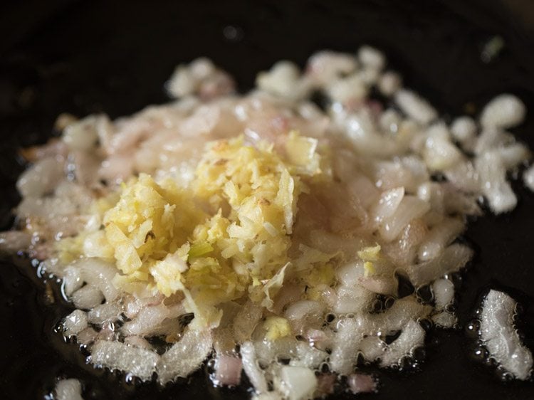 Garlic paste added to diced onions sautéing in skillet.