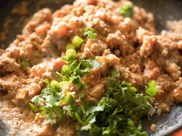 chopped green chilies and chopped coriander leaves added to tomato mixture for making brinjal curry.