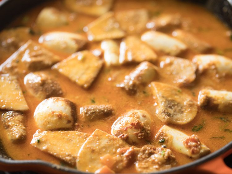 Closeup shot of baingan masala cooking in skillet.