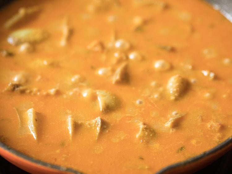 Closeup shot of cooked baingan masala cooking in skillet.