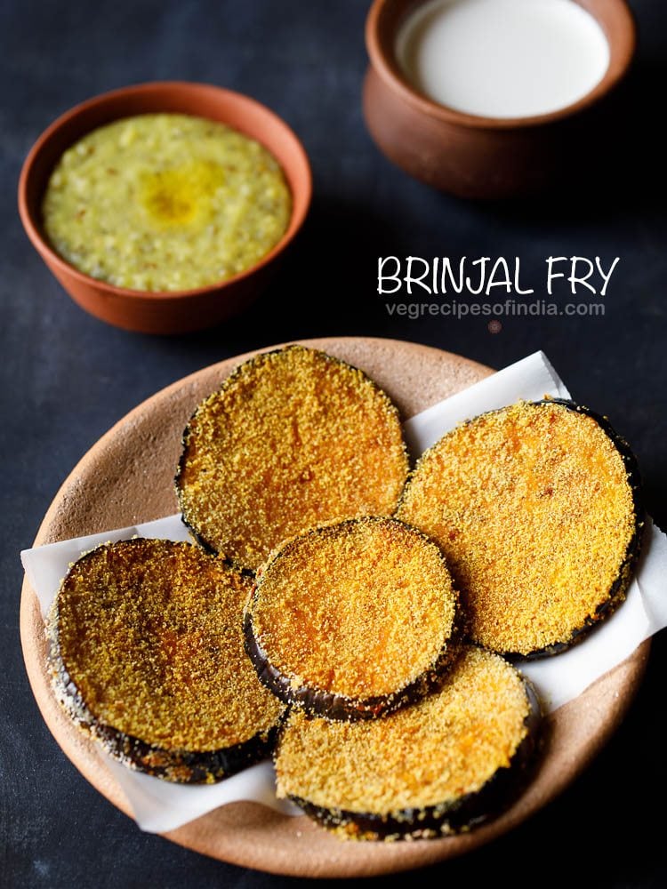 brinjal fry served on a butter paper placed on a ceramic plate with a bowl of khichdi and curd kept in the background and text layover.