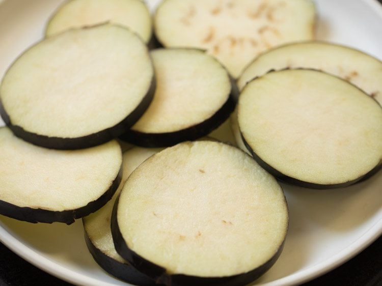 brinjal sliced drained and placed on a plate. 