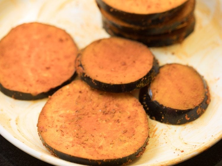 brinjal slices coated evenly with salt and spice powders. 