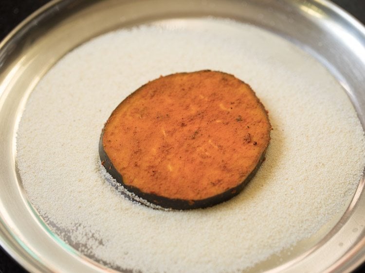 marinated brinjal slice placed on rava. 