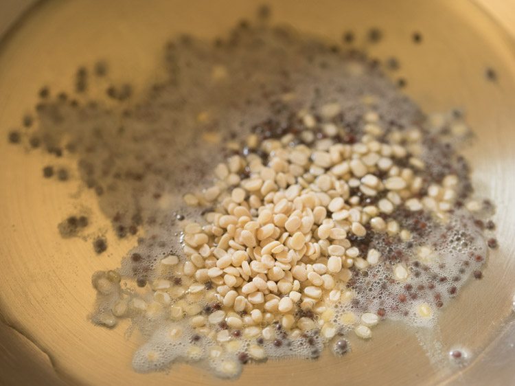 urad dal added to the hot oil in the pan for making kadalai paruppu sundal. 