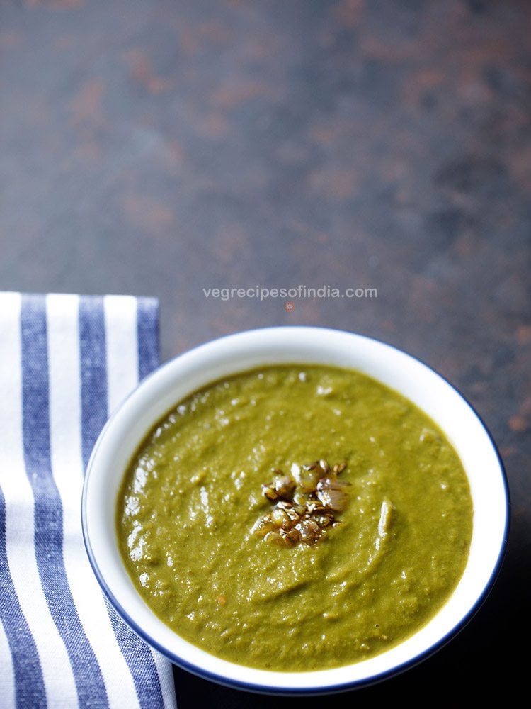 chane ka saag served in a blue rimed white bowl. 