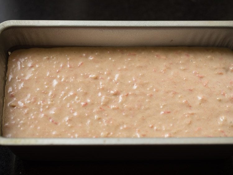 carrot cake batter spread evenly in the loaf pan