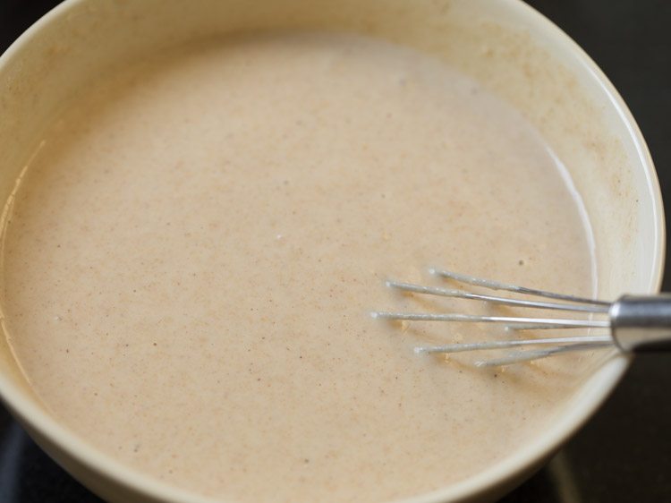 pancake batter with wired whisk in bowl.