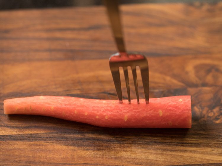 pricking carrot with fork. 