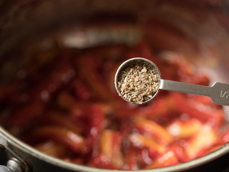 adding cardamom powder to gajar ka murabba. 