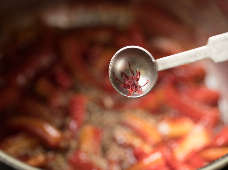 adding saffron strands to gajar ka murabba. 