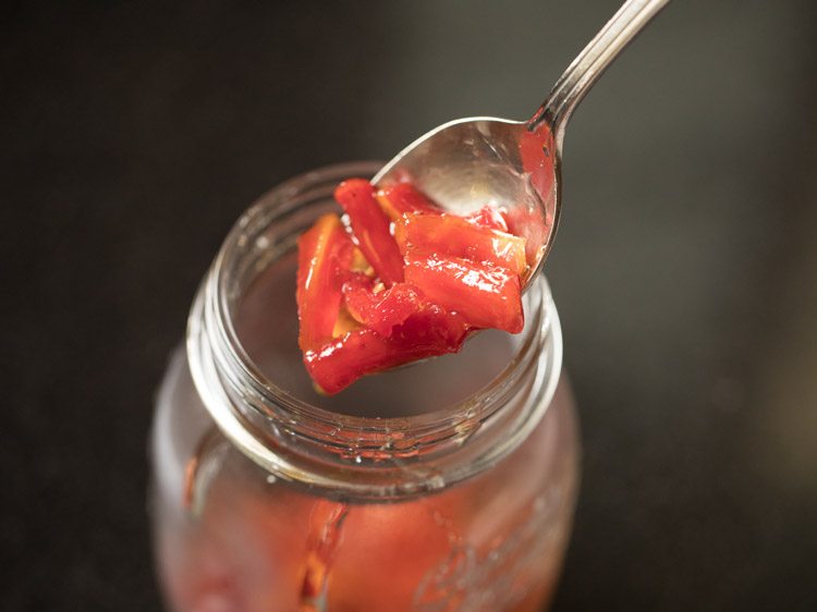 adding prepared gajar ka murabba in a clean glass jar. 